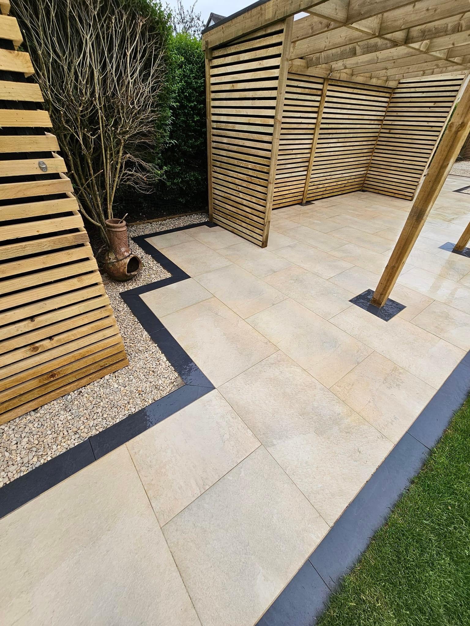 Large porcelain patio with a slatted privacy screen and feature planting