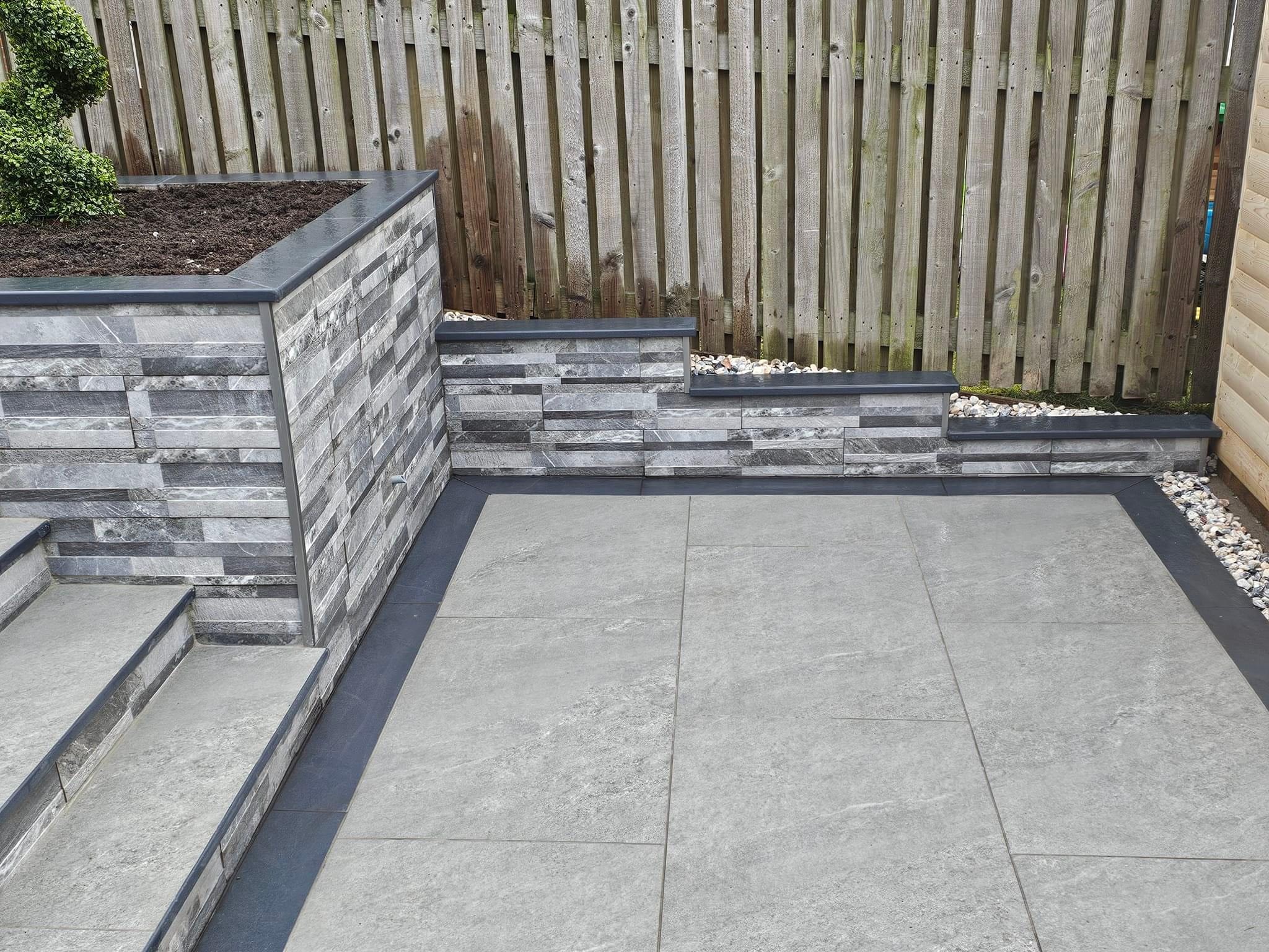 Tiered patio with steps and a stone-faced retaining wall