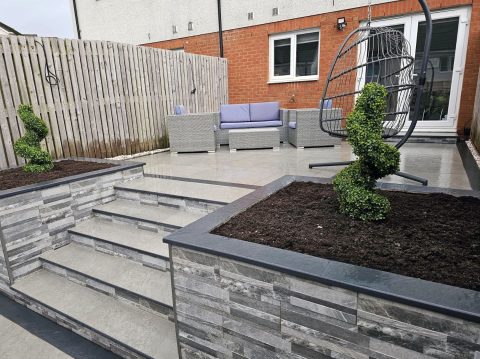 Paved seating area with sleeper-built raised beds