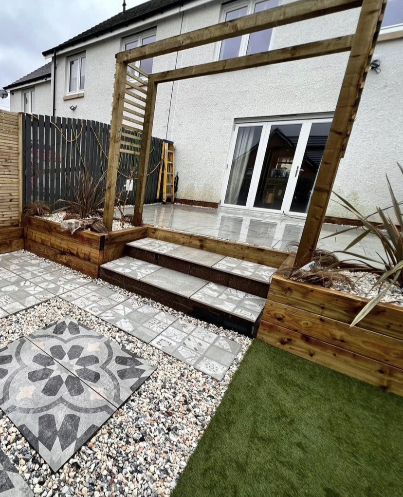 Paved patio with steps leading up to a lawn
