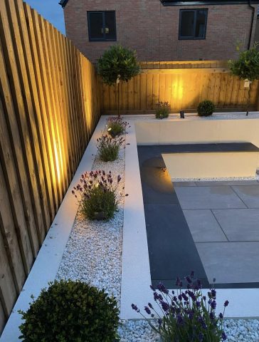 Decorative tiled pathway with a gravel border between properties